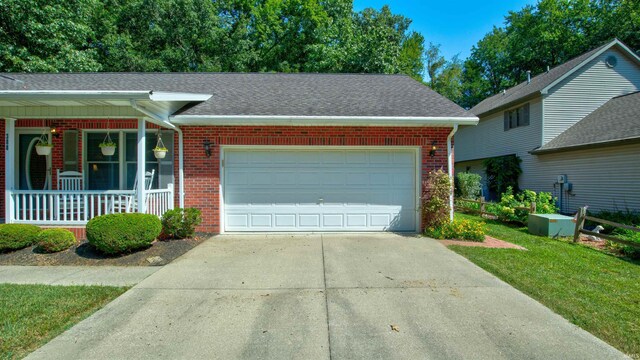 view of front facade with a garage, a front lawn, and a porch