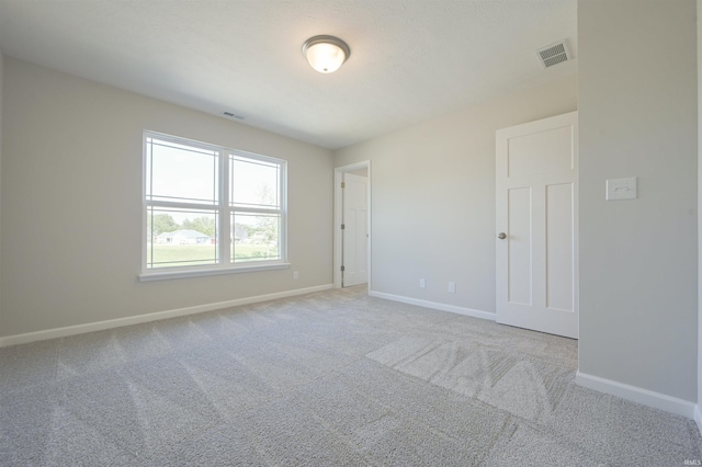 unfurnished room featuring light carpet