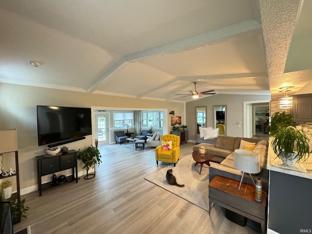 living room featuring a ceiling fan, light wood finished floors, baseboards, and vaulted ceiling