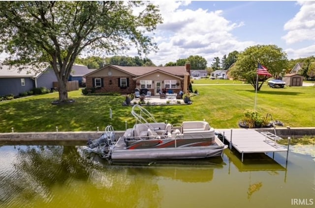 view of dock featuring a patio, a water view, and a lawn