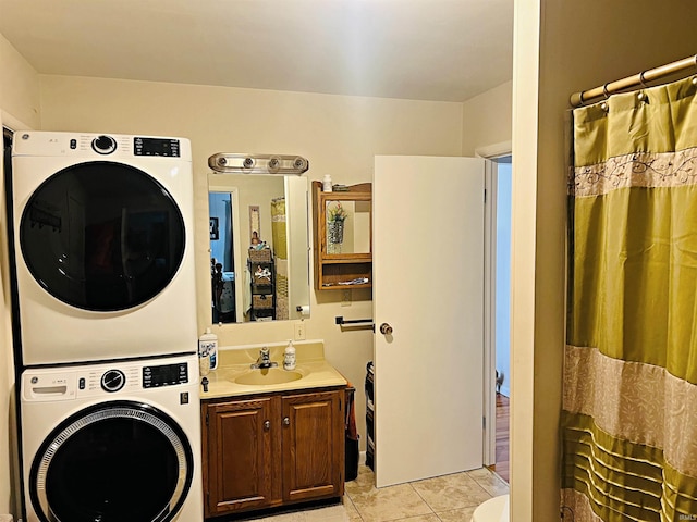 washroom featuring light tile patterned flooring, stacked washing maching and dryer, and sink