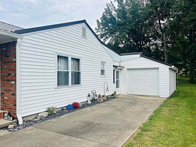 exterior space featuring a garage, a yard, and an outbuilding