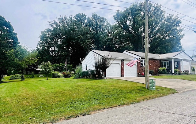 view of side of home featuring a garage, a yard, brick siding, and driveway