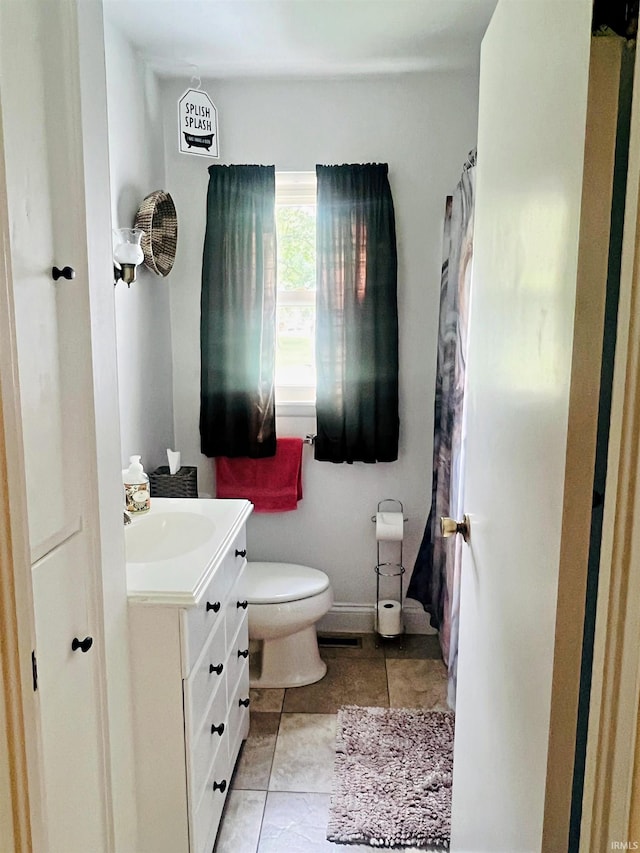 bathroom with toilet, tile patterned floors, and vanity