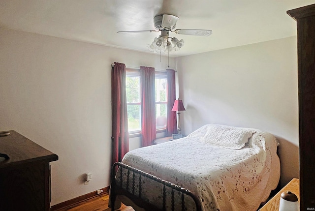 bedroom with a ceiling fan, baseboards, and wood finished floors