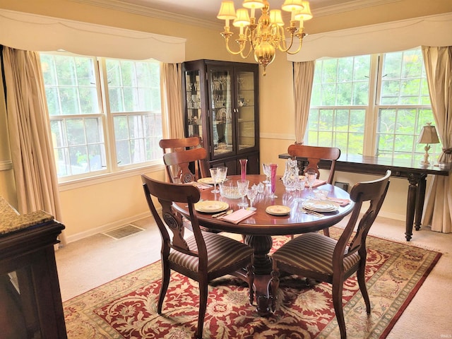 carpeted dining area with crown molding, plenty of natural light, and a chandelier