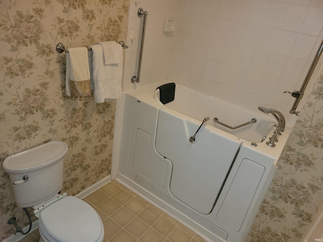 bathroom featuring a tub to relax in, tile patterned floors, and toilet