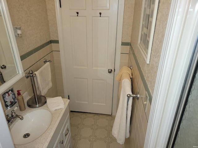 bathroom with vanity and tile walls