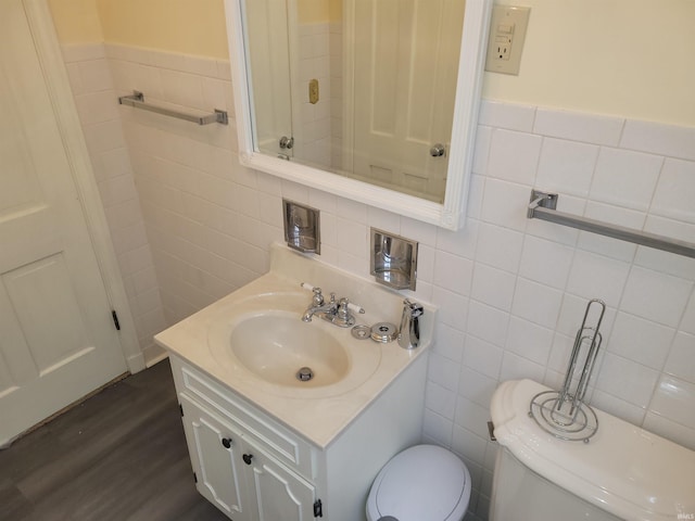 bathroom with tile walls, vanity, hardwood / wood-style floors, and toilet