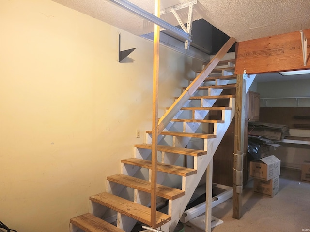 stairs featuring concrete flooring