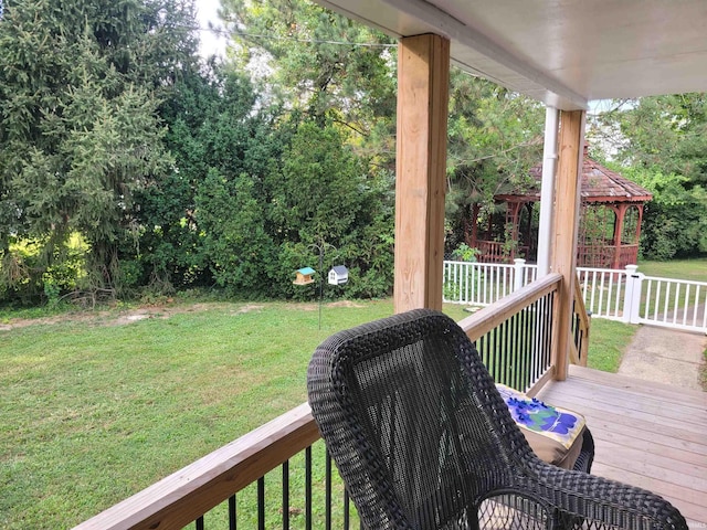 wooden terrace featuring a gazebo and a lawn