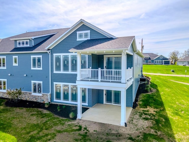 rear view of property with a balcony, a patio area, a yard, and cooling unit