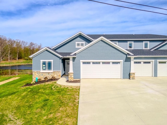 craftsman house featuring a garage and a front lawn