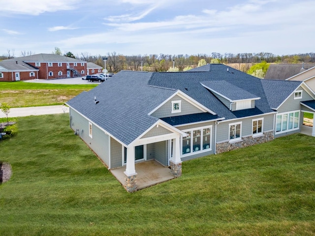 back of property with a patio area and a yard