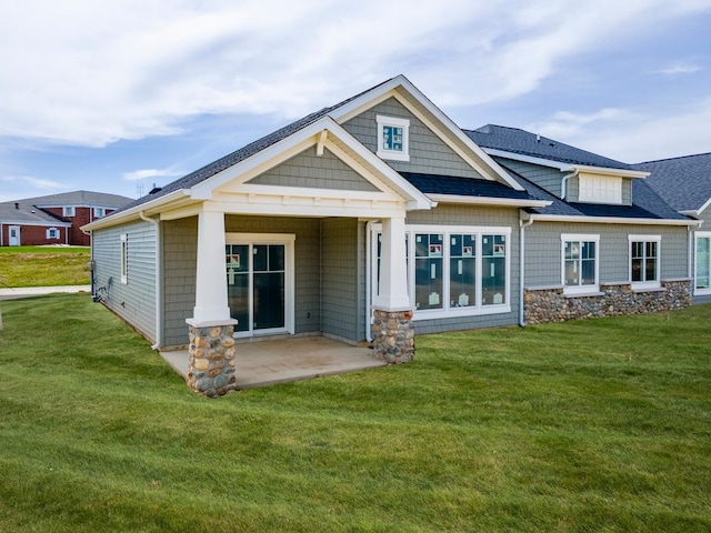 rear view of property with a yard and a patio area