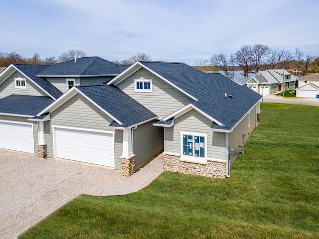 craftsman house featuring a garage and a front lawn