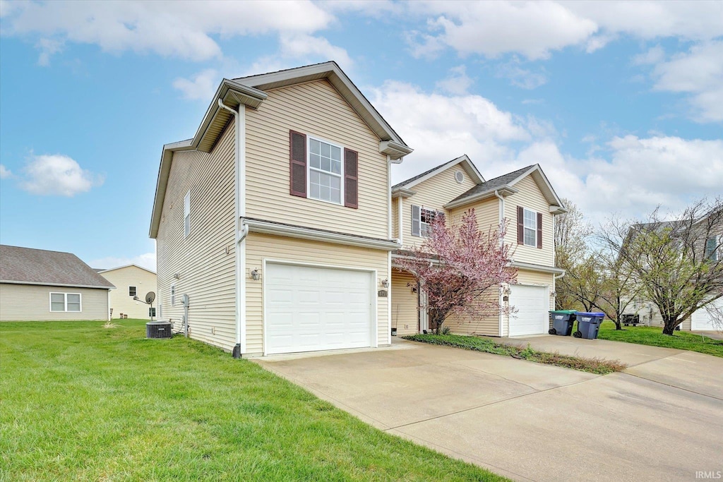 view of front of home featuring central air condition unit, a front yard, and a garage