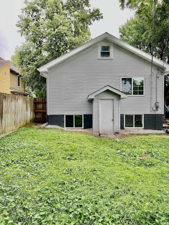 rear view of property featuring a lawn