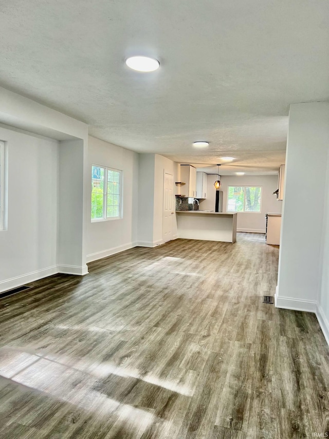 unfurnished living room featuring hardwood / wood-style floors and plenty of natural light