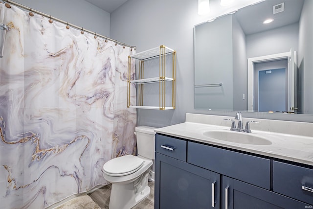 bathroom with vanity, toilet, and wood-type flooring