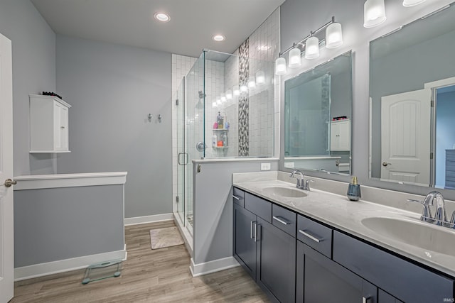 bathroom with walk in shower, wood-type flooring, and vanity