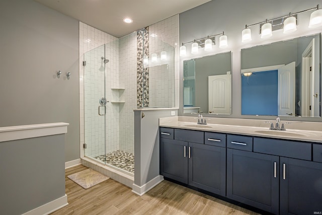 bathroom with an enclosed shower, hardwood / wood-style floors, and vanity