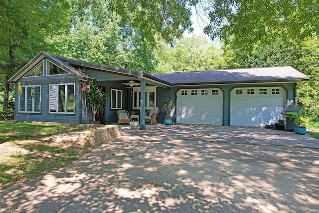 view of front of property featuring aphalt driveway, an attached garage, and a ceiling fan