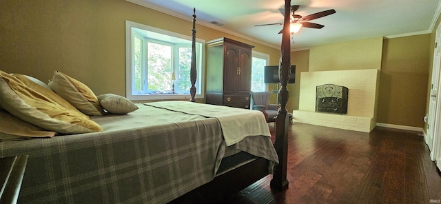 bedroom with visible vents, baseboards, dark wood finished floors, a fireplace, and crown molding