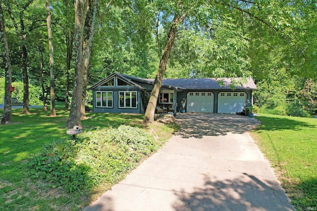 view of front of house featuring an attached garage, concrete driveway, and a front yard