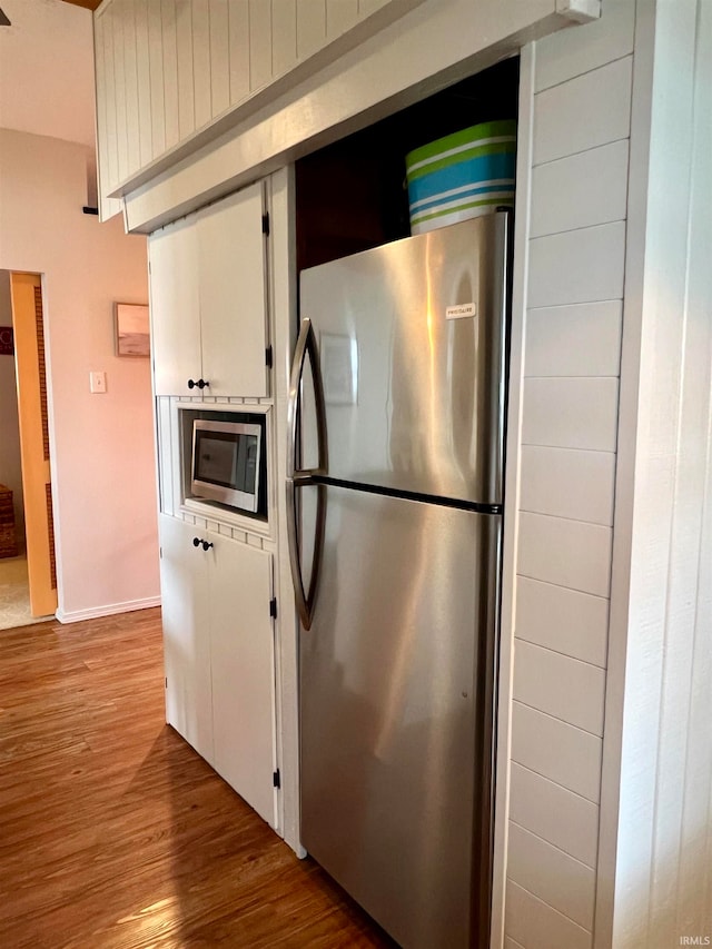 kitchen featuring white cabinets, wood-type flooring, and stainless steel appliances