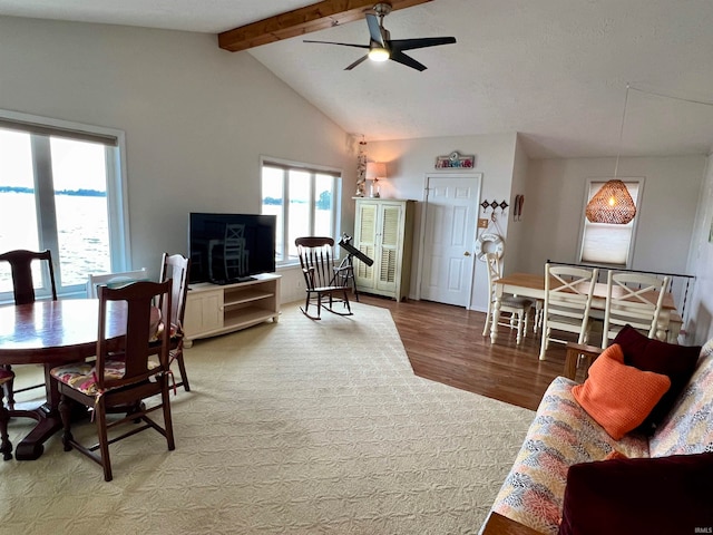 living room with ceiling fan, vaulted ceiling with beams, and hardwood / wood-style floors