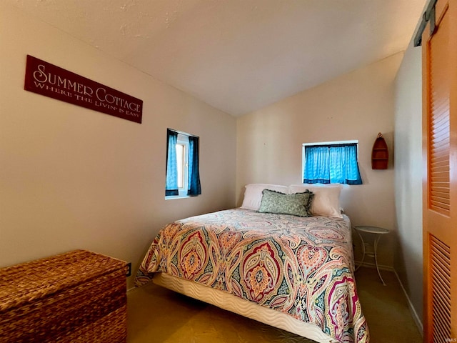 carpeted bedroom featuring lofted ceiling