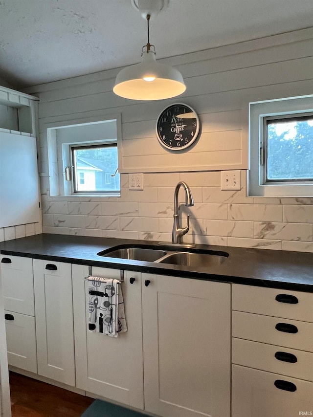 kitchen with sink, white cabinetry, dark hardwood / wood-style floors, and backsplash