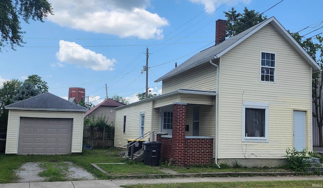 view of front facade featuring a garage and an outbuilding