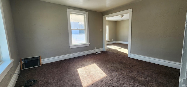 spare room featuring dark carpet