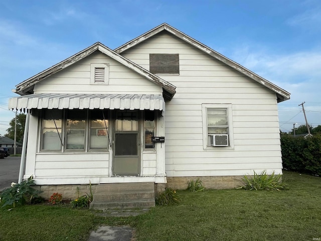 bungalow with cooling unit and a front lawn