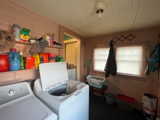 laundry room with independent washer and dryer and wooden walls