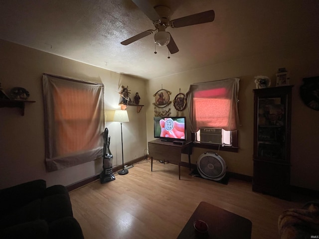 living room with ceiling fan, wood-type flooring, a textured ceiling, and cooling unit