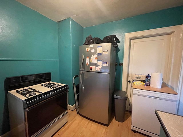 kitchen with light hardwood / wood-style flooring and white appliances