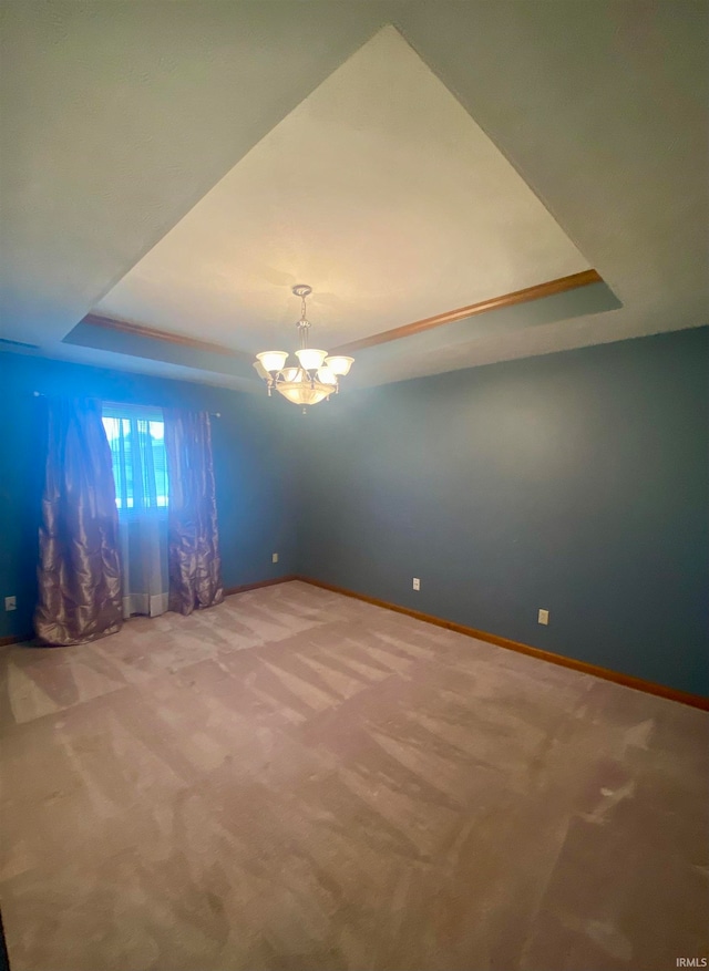 interior space with a tray ceiling and a chandelier