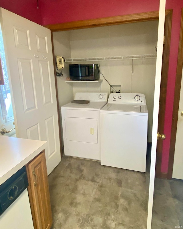 clothes washing area featuring washing machine and clothes dryer and light tile patterned floors