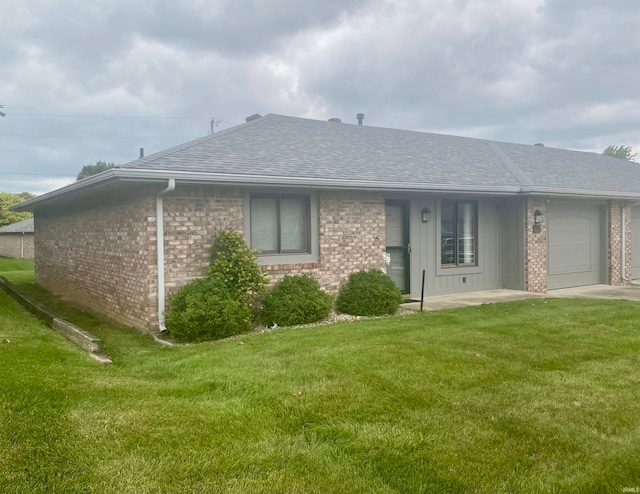 back of house with a garage and a yard