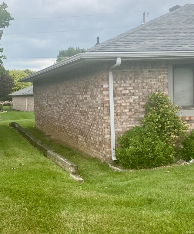 view of side of home with a yard