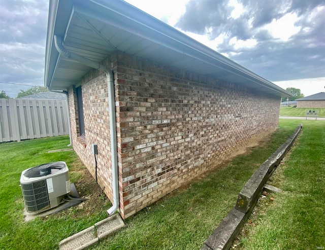 view of side of property with central AC unit and a yard