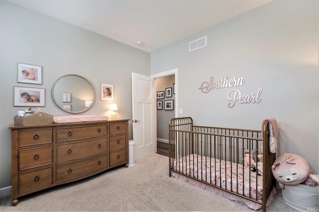 bedroom with a crib and light colored carpet