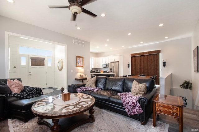 living room featuring ceiling fan and light hardwood / wood-style flooring