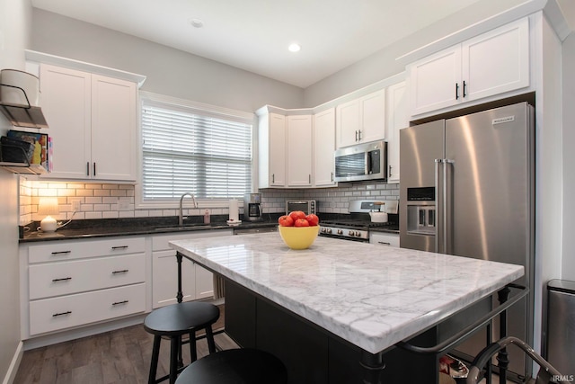 kitchen with appliances with stainless steel finishes, sink, tasteful backsplash, and a center island