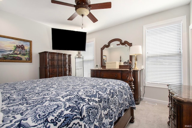 carpeted bedroom with ceiling fan and multiple windows