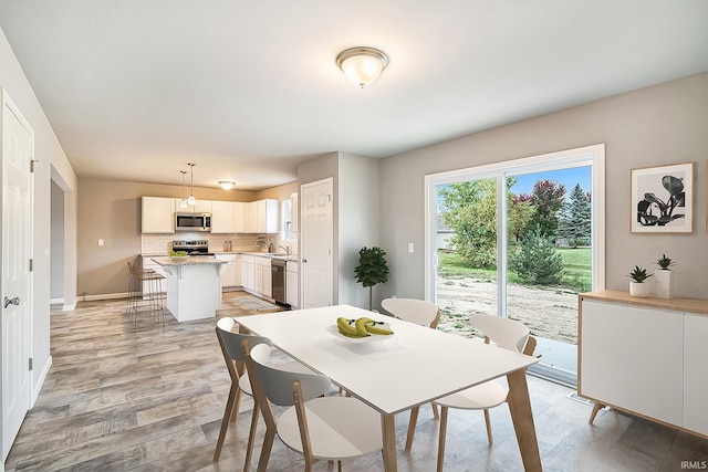 dining room with sink and light hardwood / wood-style floors