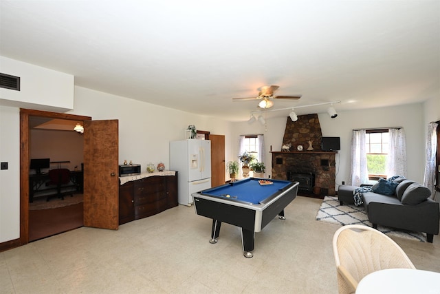 game room featuring light tile patterned floors, a stone fireplace, pool table, track lighting, and ceiling fan